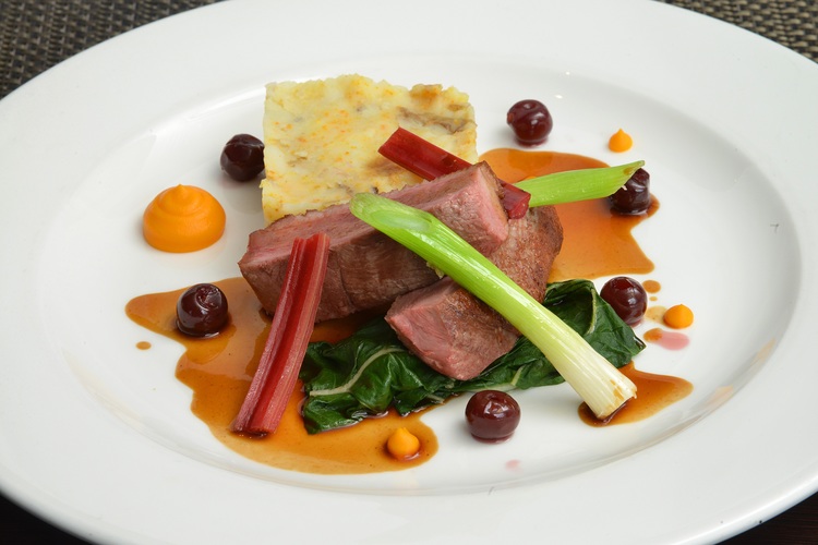 Gressingham duck breast with orange crushed potatoes, cherries, Swiss chard and spiced jus.