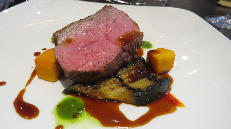 Roasted rump of lamb with bell pepper puree, aubergine courgette, sweet potato, pesto and lamb jus.