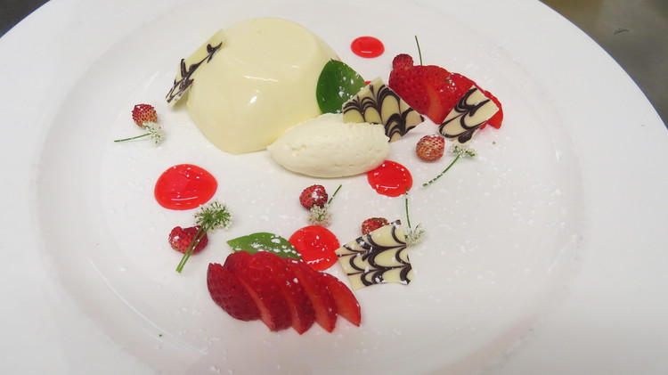 Sweet cicely and wild strawberries as garnish on a pannacotta dessert.