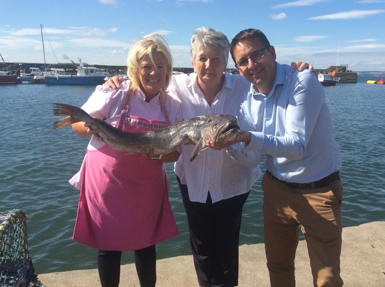 Jak O'Donnell, Shirley Spears and James Withers, Chief Executive of Scotland Food & Drink, check out the seafood on offer in Mallaig.