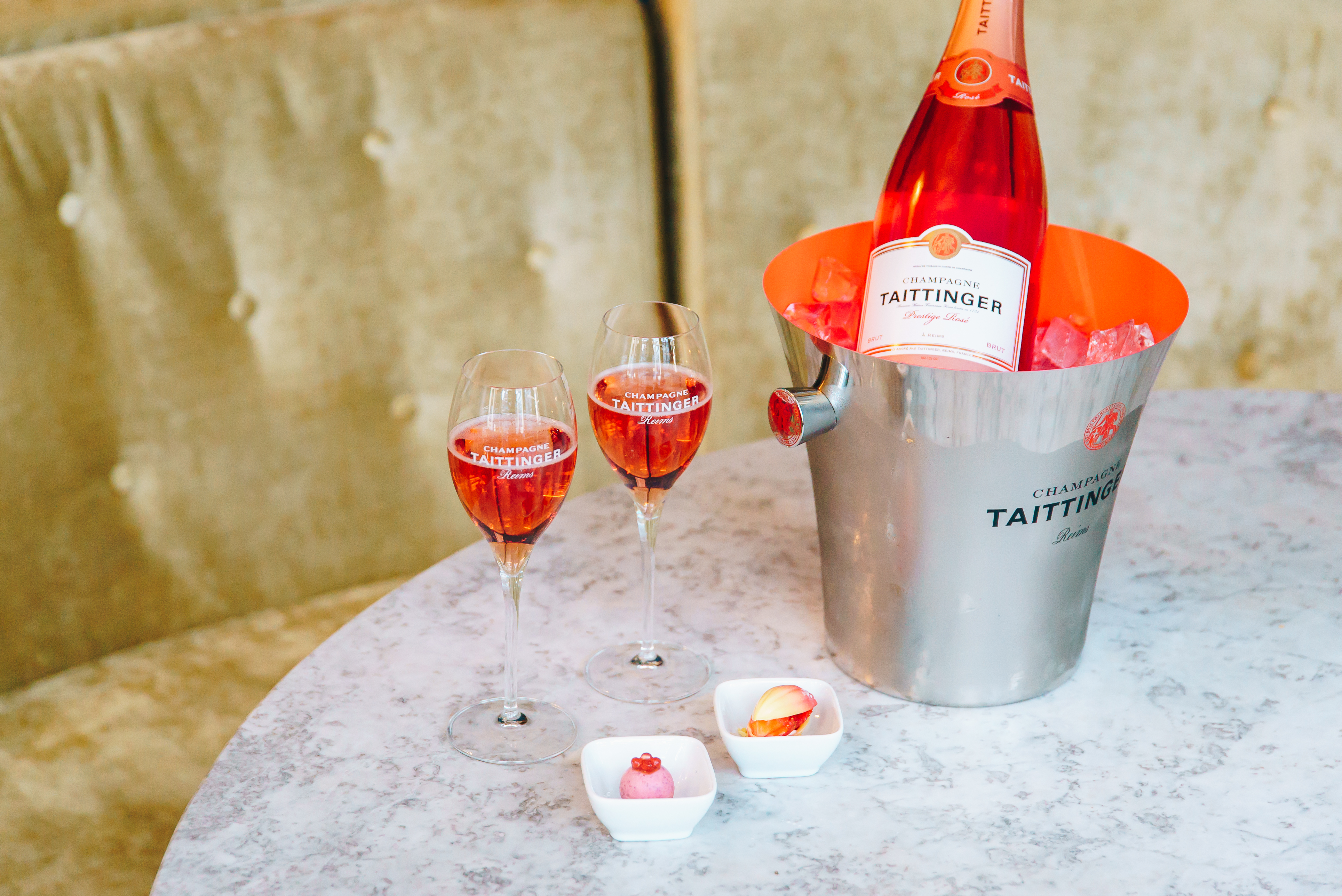 Bottle of Taittinger Prestige Rosé NV in ice bucket with canapes